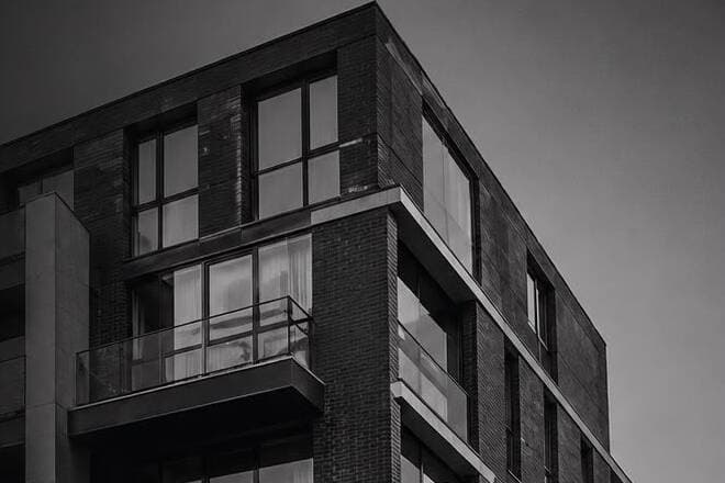 Exterior of a converted warehouse apartment building at dusk.