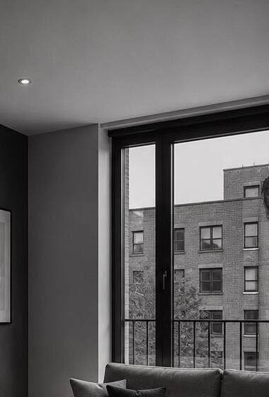 Floor-to-ceiling apartment window looking onto the city.